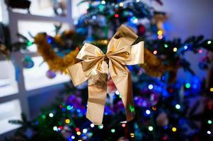 Golden bow at christmas tree with lights photo