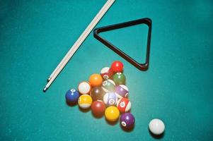 Billiard balls in a pool table at triangle with billiard cue photo