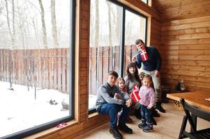 Family with Denmark flags inside wooden house. Travel to Scandinavian countries. Happiest danish people's . photo