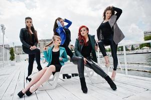 Five beautiful young girls models at leather jackets posing on berth. photo