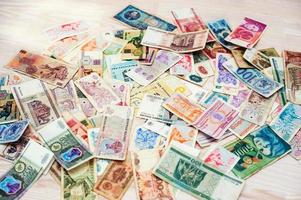 Many old money of different countries on wooden background photo