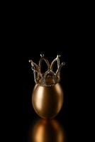 Golden egg in a crown on a black background close up photo