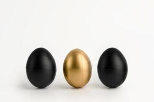 Three Easter black golden decorated eggs on white background. photo