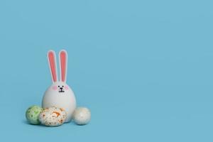 White cute toy rabbit with multicolored eggs isolated on blue background photo