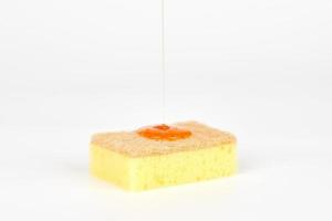 Orange detergent on sponge liquid, dish soap on sponge, dishwashing sponge for general cleaning day photo