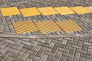 pavimentación táctil amarilla en la pasarela, indicadores táctiles de la superficie del suelo para ciegos y deficientes visuales foto