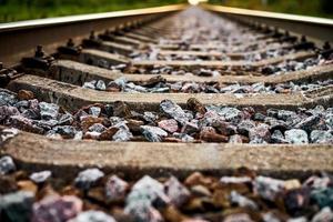 Railway track line going into distance, railroad train track with crushed stone, two parallel rails photo