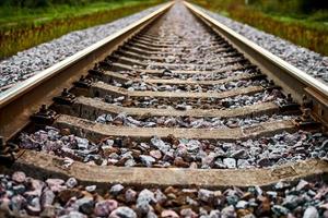 Railway track line going into distance, railroad train track with crushed stone, two parallel rails photo