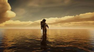 spaceman dans la mer sous les nuages au coucher du soleil