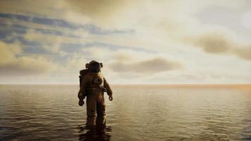 Spaceman in the sea under clouds at sunset video