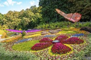 Butterfly and dragonfly figure standing in colorful flowers exhibition at garden photo