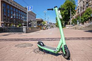 Electric scooter parked on city footpath for urban mobility photo