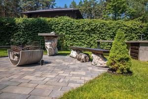 Iron fire pit with benches on stone pavement in garden backyard photo