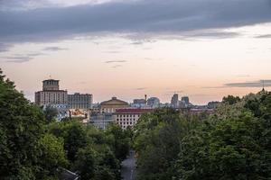 camino rural con el horizonte de la ciudad de kiev y monumento contra el cielo nublado foto