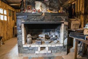 Stone brick wall fireplace with antique tools in abandoned room photo