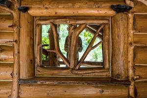 pared de troncos con reflejo de la persona en la ventana de marco decorativo de vidrio foto