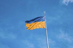 Bicolor blue and yellow national flag of ukraine waving in wind against sky photo