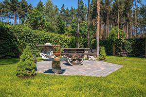 Iron fire pit with bench on stone pavement in garden backyard photo