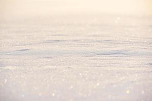 Texture of white snow sparkling in the sun. The foreground and background are blurred. photo