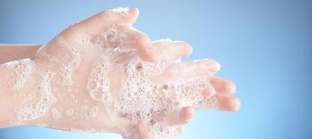 Washing female hands isolated on blue background. photo