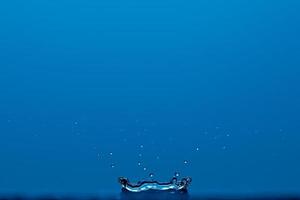 Pure clear water splash isolated on blue background. photo