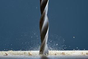 Wood drill bit in the blur with shaving on a gray background. Drill bit in the center of the frame.