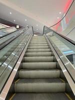 escalator in the mall. moving staircase. ascent and descent in the interior. move up or down stairs photo