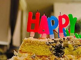 la palabra feliz en forma de velas en el pastel de cumpleaños.