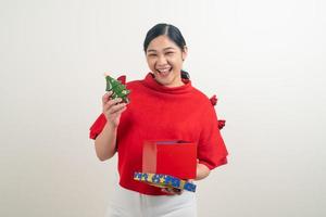 happy Asian woman wearing red shirt with gift box on hand for Christmas festival photo