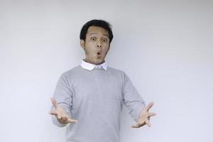 Wow and shocked face of Young Asian man with open hand gesture. Advertising model concept. photo