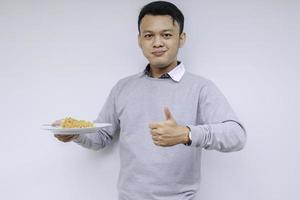 Portrait of happy Young Asian man enjoys noodles. Eating lunch concept photo