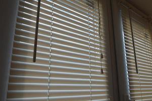 Horizontal blinds shine sunlight into the room photo