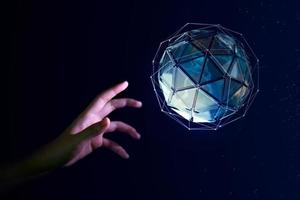 Human hand about to touch the earth globe, Earth Day concept photo
