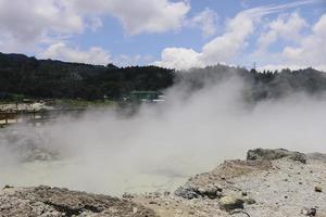 Sikidang crater with the background of sulfur vapor coming out of the sulfur marsh. photo