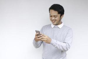 Smart Young asian man is happy and smiling when using smartphone in studio background photo