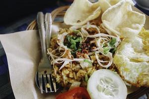 A plate of oriental food Special fried rice from Indonesia with crackers isolated on wooden table photo