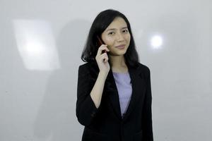Business young asian girl is happy using a laptop and talking on phone photo