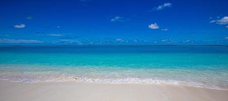 primer plano de arena en la playa y cielo azul de verano. paisaje panorámico de la playa. playa tropical vacía y paisaje marino. cielo azul brillante, arena suave, calma, luz solar tranquila y relajante, estado de ánimo de verano foto