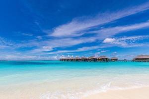 Amazing island beach panorama at Maldives. Luxury resort villas seascape bright blue sky clouds. Beautiful beach background for vacation holiday