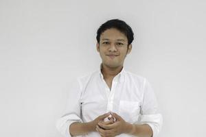 retrato de un joven asiático divertido con camisa blanca mirando a la cámara y sonriendo feliz expresión foto