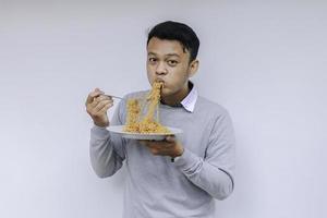 el joven asiático disfruta de los fideos. comer el concepto de almuerzo. foto