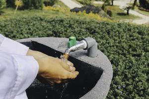 Women washing hands with nature background under the sunlight. Hygiene concept hand detail. photo