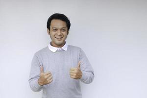 Young Asian man wear grey shirt with happy smiling face and thumbs up or ok sign photo