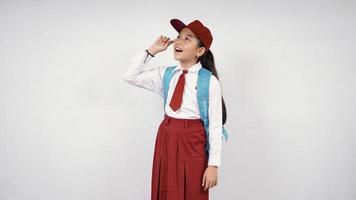 Beautiful elementary school girl thinking good idea isolated on white background photo