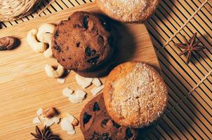 Round crispy chocolate cookies with spices and nuts on cutting board photo