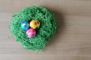 top view of easter eggs and grass decoration on table photo