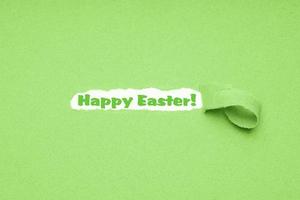 Happy Easter greeting on torn green paper background photo