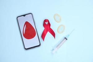 red ribbon and medical device symbol against HIV virus isolated on blue background photo