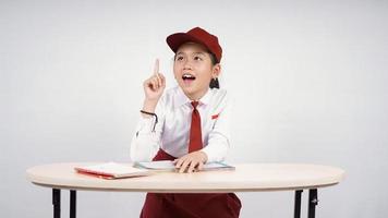 Elementary school asian girl finds great idea isolated on white background