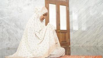 mujer musulmana asiática rezando con suerte en la mezquita foto